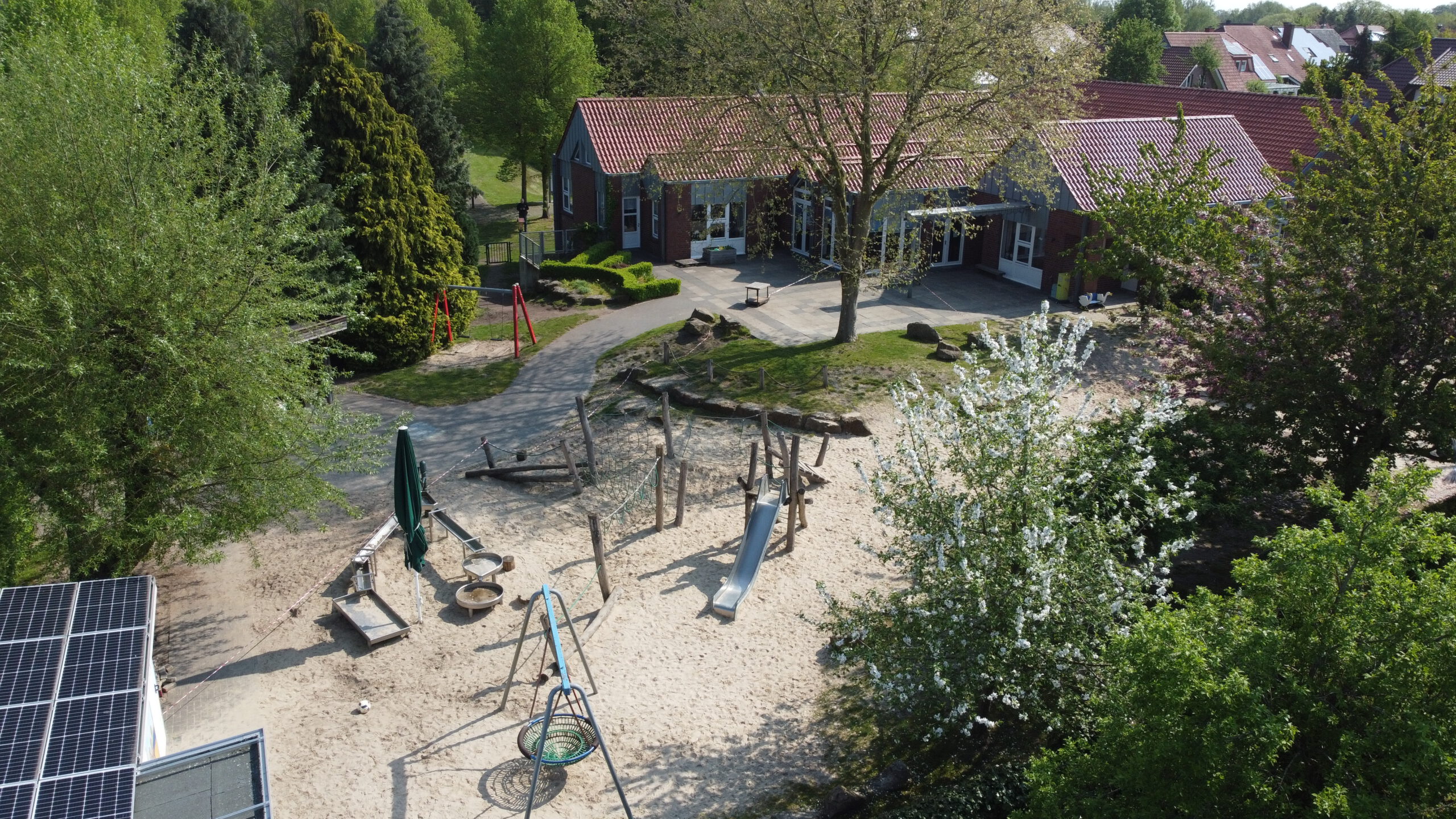 Luftaufnahme der Kindertagesstätte neben Kirche und Burgpark in Venhaus